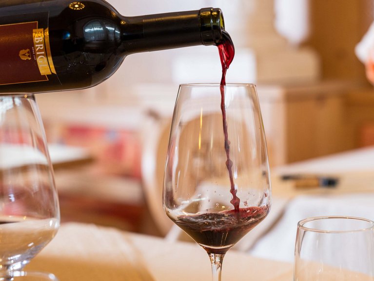 I nostri fornitori di fiducia: solo prodotti di qualità! Vino rosso che viene versato in un calice da una bottiglia su un tavolo