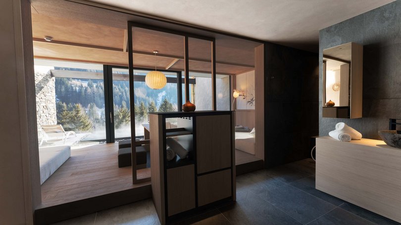 La pista ciclabile in Val di Fassa? C’è molto di più! Interno moderno di spa con vista su paesaggio montano da grandi finestre