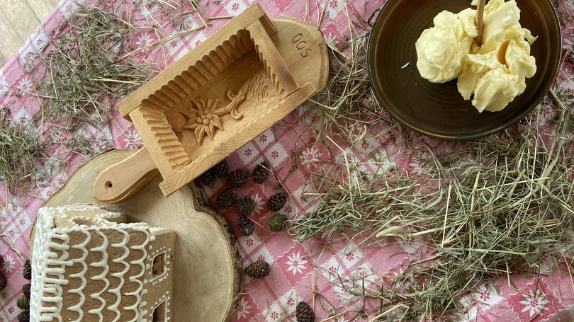 Escursioni da Moena e molto altro: il nostro programma Casa di pan di zenzero, ciotola di burro, stampo di legno e fieno su tovaglia