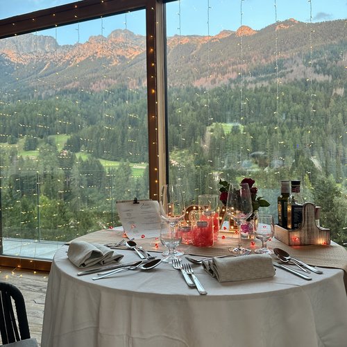 Ristorante a Soraga di Fassa: Mirage con #latermarview Tavolo apparecchiato con vista sulle montagne dalla finestra grande