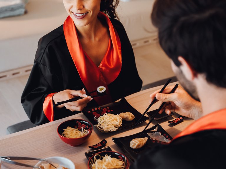 Val di Fassa in estate o inverno? Il relax non ha tempo! Coppia che mangia sushi e noodles indossando kimono neri con dettagli rossi