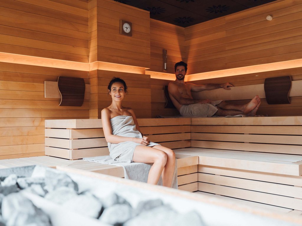 Al Latemar, dopo le passeggiate: relax nella Spa Oniro Due persone sedute rilassate in sauna di legno