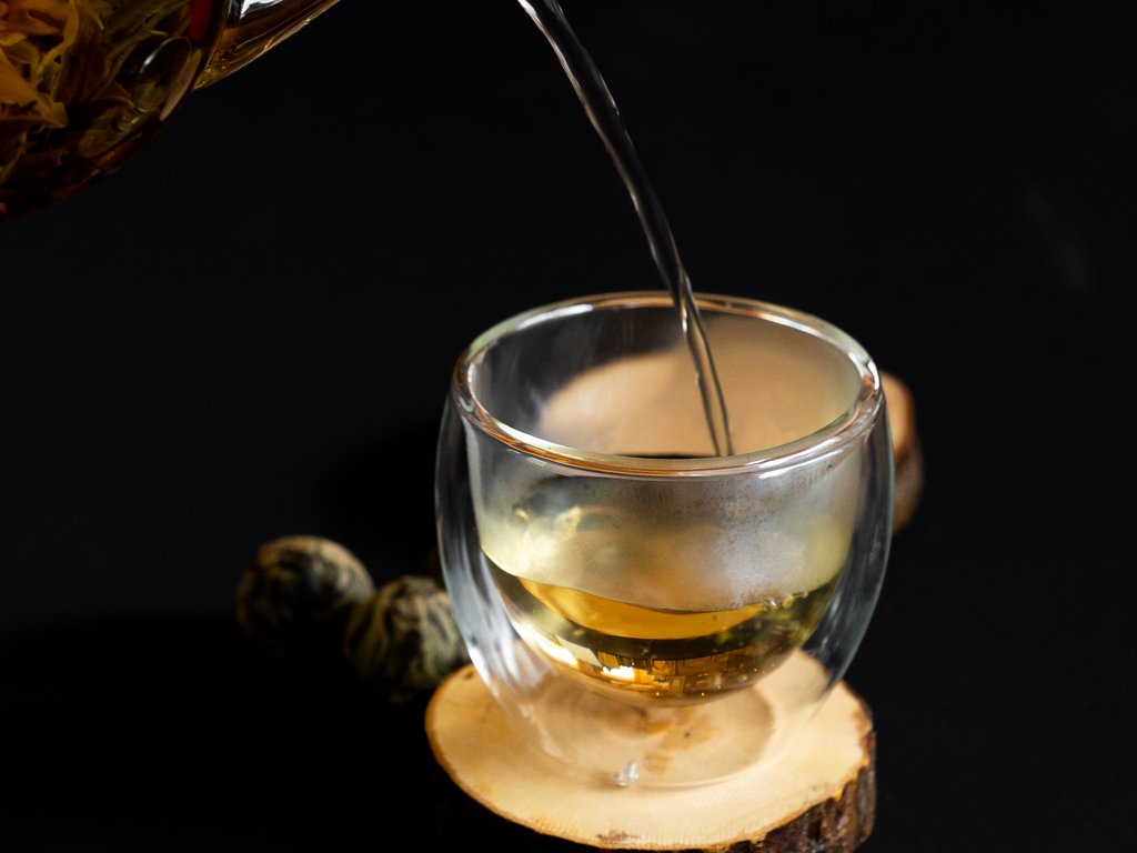 Val di Fassa e ciclabile: da ammirare dal cocktail & tea bar Tè versato da una teiera in vetro in una tazza su una base di legno