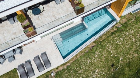 Meteo, Moena, Soraga, Latemar: tutto nella nostra gallery Terrazza moderna con lettini e piscina vicino a un edificio con struttura in legno.