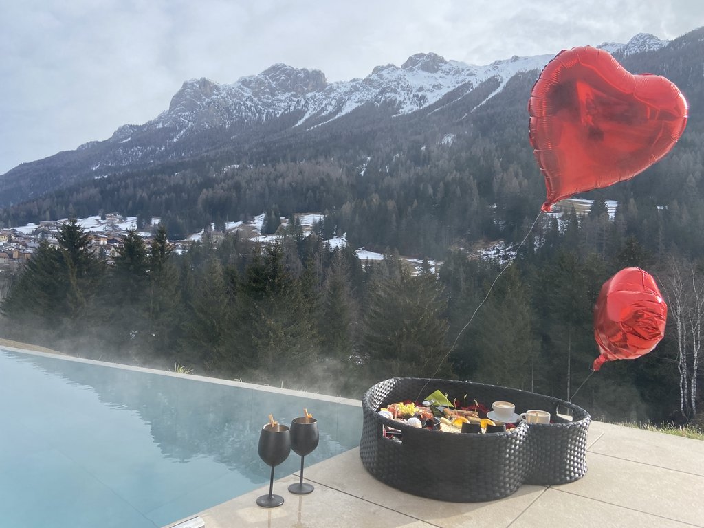 A Soraga il meteo è sempre ottimo per un Day Spa! Piscina all'aperto con vista sulle montagne e cesto con cibo e palloncini a forma di cuore