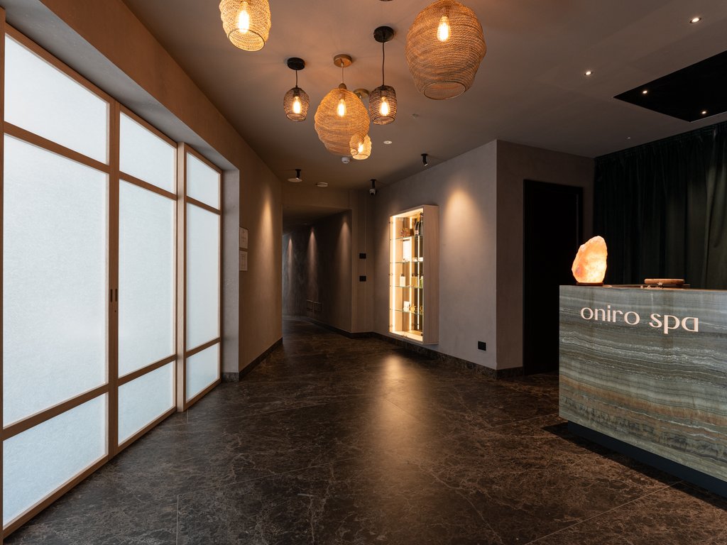 Soraga: dal lago alla piscina del Latemar Ingresso moderno e accogliente della spa Oniro con luci soffuse e arredi eleganti