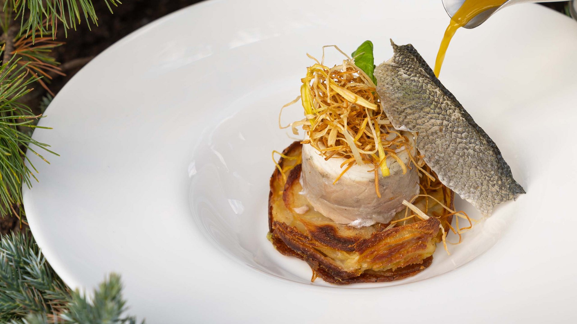 Ristorante gourmet in Val di Fassa: il Mirage al Latemar Piatto gourmet con pesce, crosta croccante e salsa versata