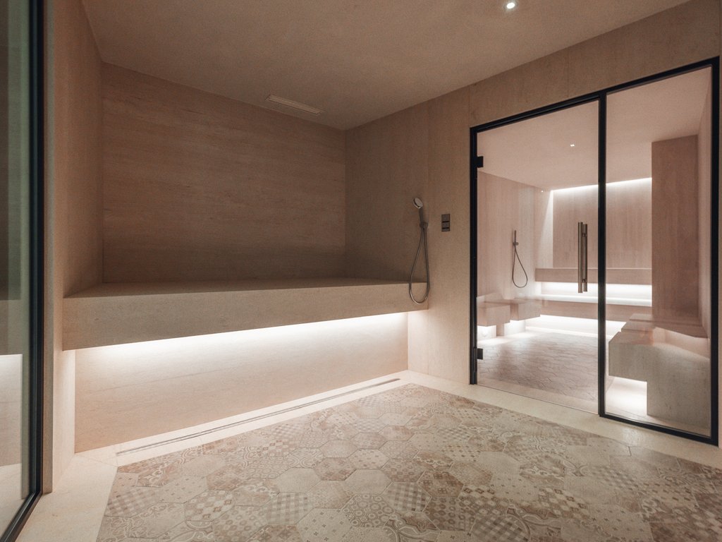 Al Latemar, dopo le passeggiate: relax nella Spa Oniro Interno sauna moderna con luci soffuse e pareti in legno chiaro