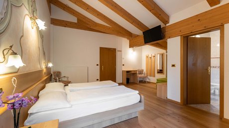 Meteo, Moena, Soraga, Latemar: tutto nella nostra gallery Camera da letto d'hotel con letto doppio, soffitto con travi in legno e bagno