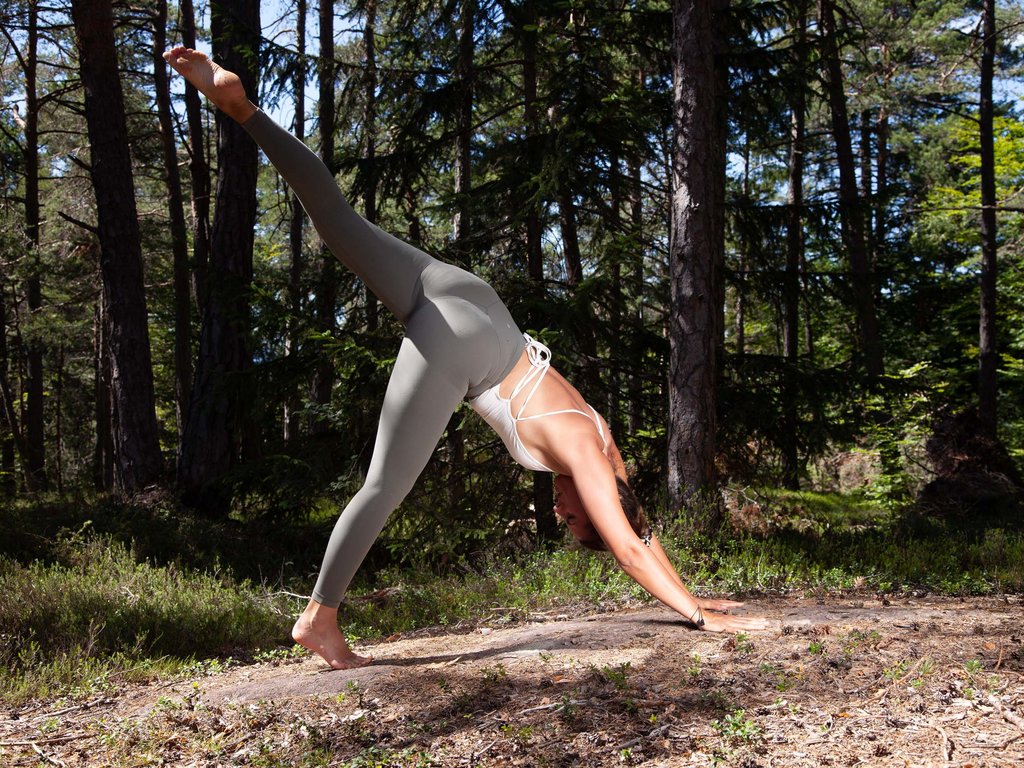 Estate in Val di Fassa, preceduta da una primavera da sogno Donna che fa yoga all'aperto nella foresta con gamba sollevata