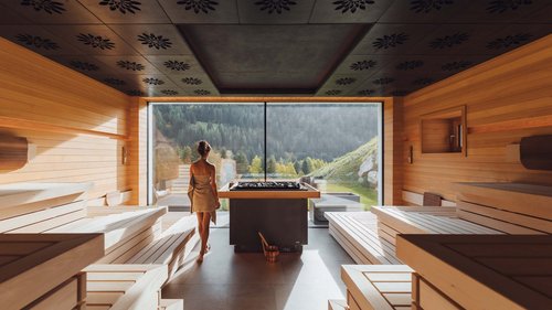 Hotel a Soraga di Fassa: benvenuti al Latemar Donna con asciugamano in sauna moderna con vista panoramica sulle montagne
