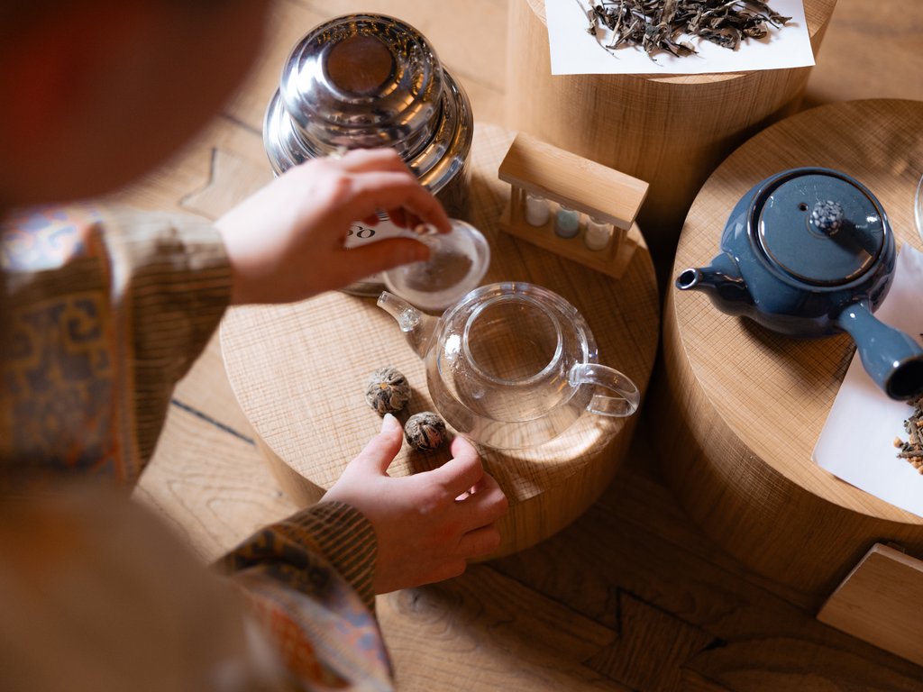 Val di Fassa e ciclabile: da ammirare dal cocktail & tea bar Persona che prepara il tè con teiere e foglie di tè su supporti di legno