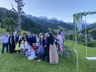 Escursioni da Moena e molto altro: il nostro programma Gruppo di persone in posa per foto in un prato con montagna sullo sfondo