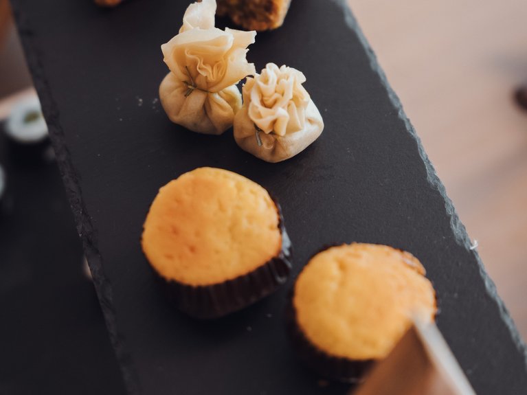 Val di Fassa in estate o inverno? Il relax non ha tempo! Assortimento di dolci e snack su piatto nero a più livelli