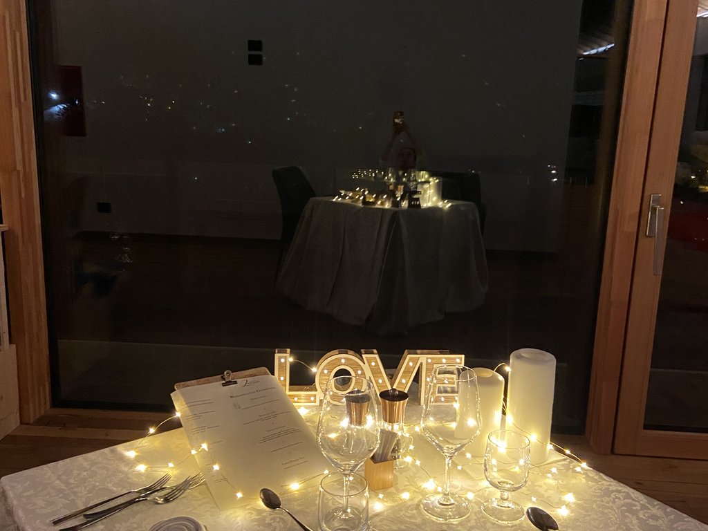 Dalla webcam il Latemar è bello, ma dal vivo è un sogno! Tavolo apparecchiato di sera con luci, decorazione 'LOVE' e tovaglioli arrotolati