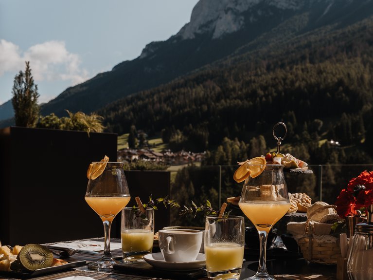 Ristorante a Soraga di Fassa: Mirage con #latermarview Colazione all'aperto con bevande e montagne sullo sfondo