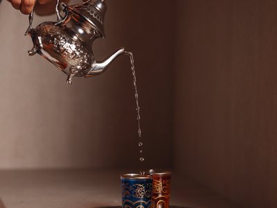 Al Latemar, dopo le passeggiate: relax nella Spa Oniro Versare tè da teiera d'argento in bicchieri decorativi su vassoio