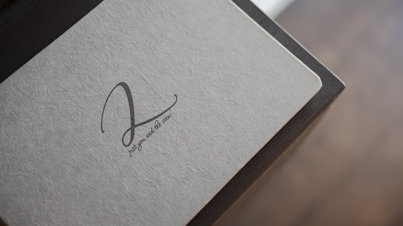 Moena, alberghi da sogno, panorama? C’è l’Hotel Latemar! Taccuino bianco con scritta elegante appoggiato su tavolo scuro