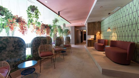 Meteo, Moena, Soraga, Latemar: tutto nella nostra gallery Sala d'attesa moderna con piante appese e divani rossi su piattaforma in legno.