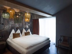 Hotel Latemar mit Dolomitenblick Modernes Schlafzimmer mit dekorativen Lampen und Doppelbett