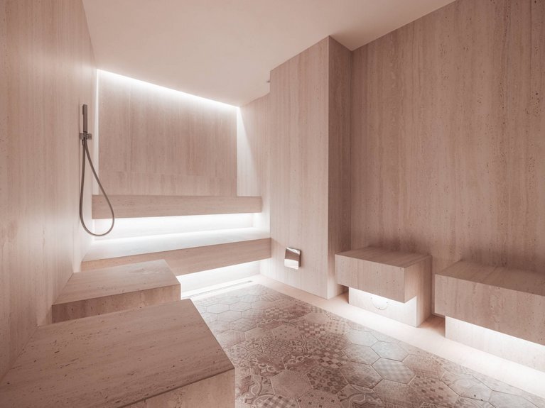Il rituale dell’hammam al Latemar Hotel Bagno moderno con pareti in pietra chiara e illuminazione integrata