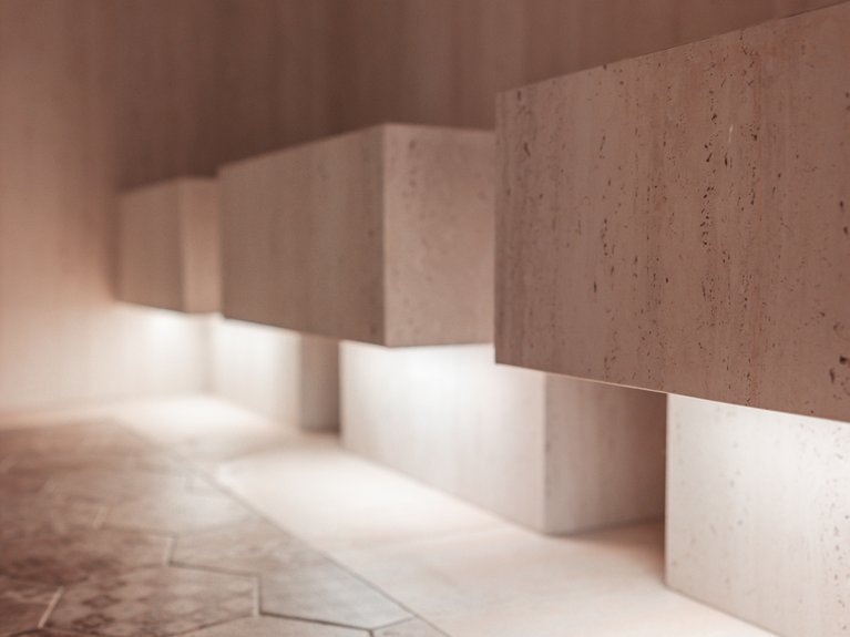 Il rituale dell’hammam al Latemar Hotel Lavabi sospesi in pietra con illuminazione soffusa su piastrelle esagonali decorative