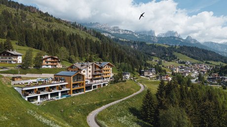 Meteo, Moena, Soraga, Latemar: tutto nella nostra gallery Hotel in collina con strada curva e montagne sullo sfondo