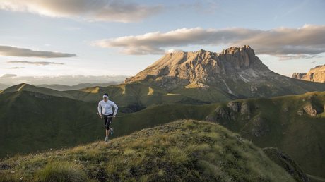 Meteo, Moena, Soraga, Latemar: tutto nella nostra gallery Persona che corre in montagna al tramonto con paesaggio delle Dolomiti sullo sfondo