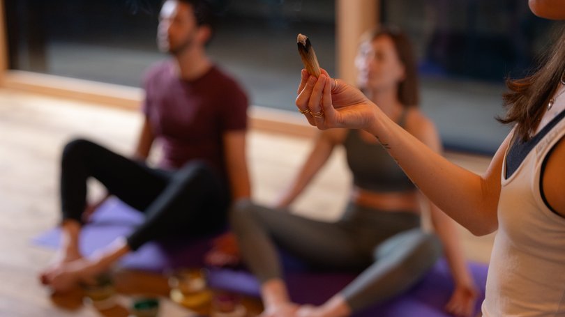 Escursioni da Moena e molto altro: il nostro programma Persona che tiene palo di salvia nel corso di meditazione yoga