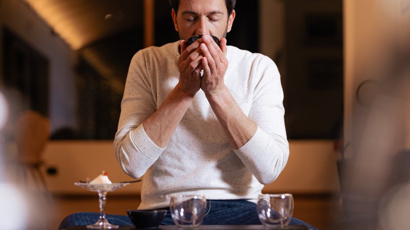 Escursioni da Moena e molto altro: il nostro programma Uomo che beve da una tazza seduto a un tavolo basso in interni accoglienti