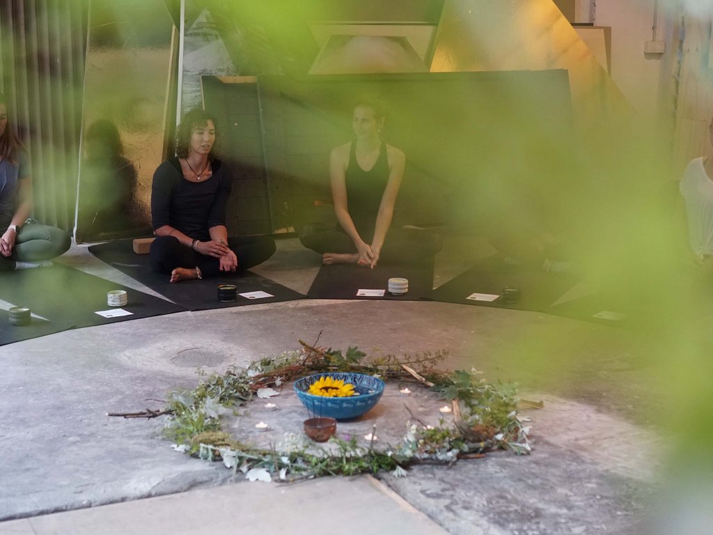 Estate in Val di Fassa, preceduta da una primavera da sogno Donne sedute in cerchio in meditazione con decorazioni di fiori e candele al centro