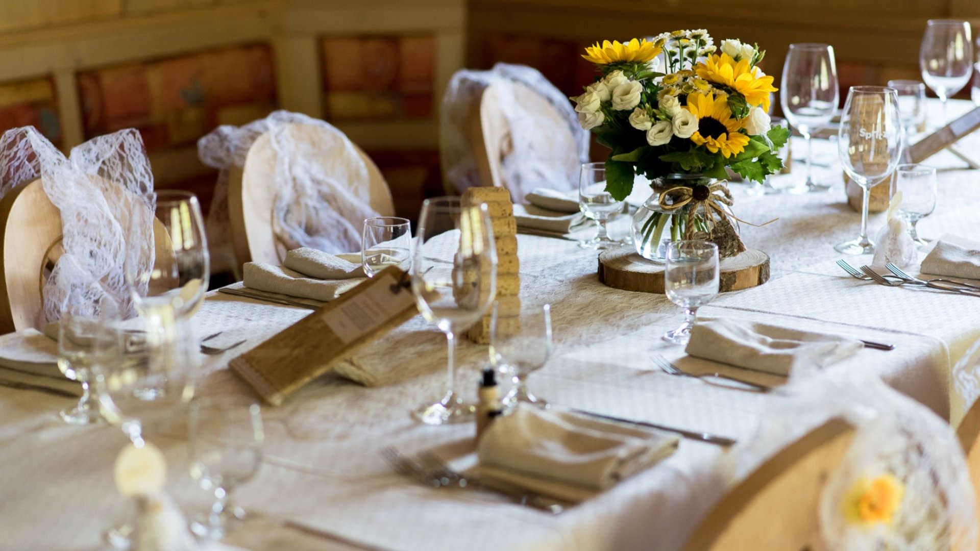 Dalla webcam il Latemar è bello, ma dal vivo è un sogno! Tavola apparecchiata elegantemente con tovaglia bianca e centro tavola con fiori gialli