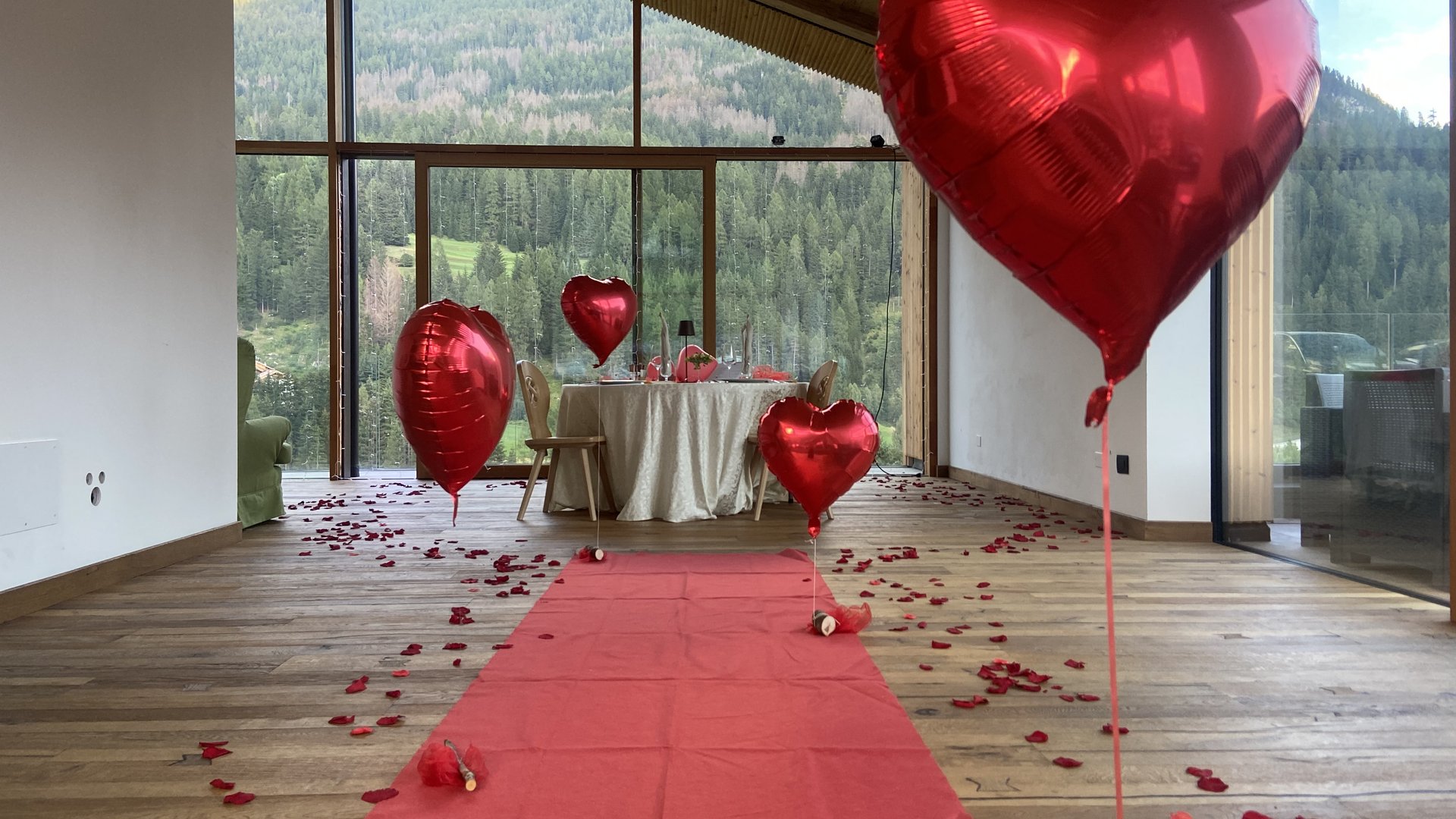 Dalla webcam il Latemar è bello, ma dal vivo è un sogno! Decorazione romantica con palloncini a forma di cuore rossi e petali di rosa