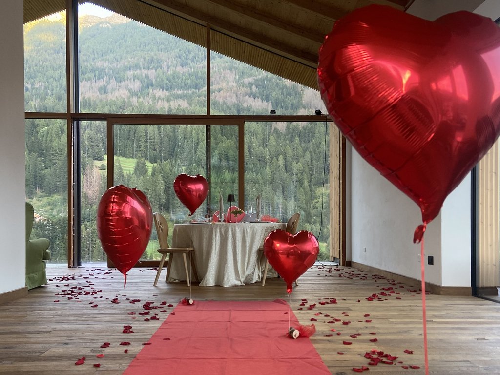 Dalla webcam il Latemar è bello, ma dal vivo è un sogno! Decorazione romantica con palloncini a forma di cuore rossi e petali di rosa