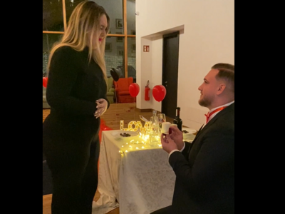 Escursioni da Moena e molto altro: il nostro programma Uomo in ginocchio che propone a donna durante cena romantica con decorazioni d'amore