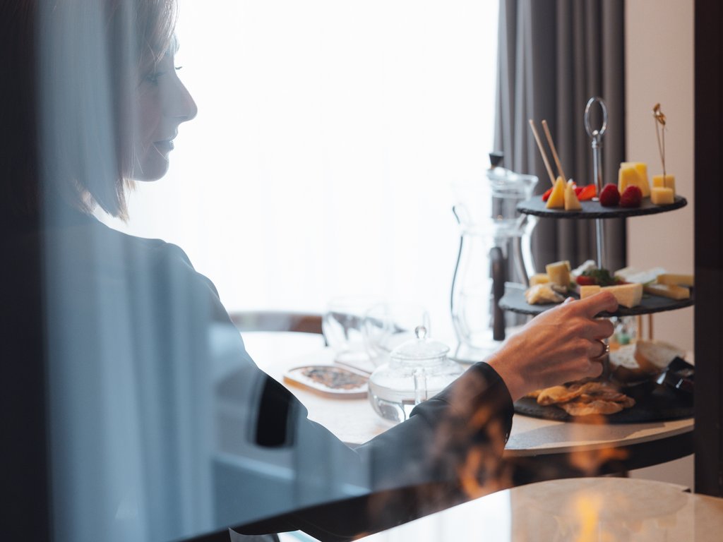 On the cycle track, from Moena to your romantic oasis Woman taking snacks from a tray in a room with a modern fireplace