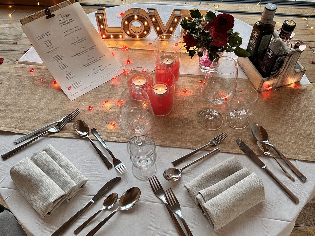 On the cycle track, from Moena to your romantic oasis Table set with candles, flowers, and illuminated LOVE decoration