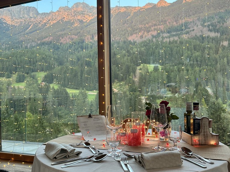Hotel Latemar con vista sulle Dolomiti Tavolo apparecchiato con vista sulle montagne dalla finestra grande