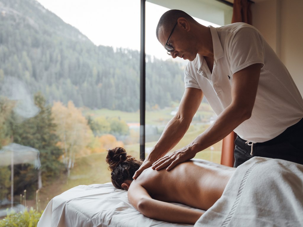 Hotel Latemar con vista sulle Dolomiti Massaggiatore che fa un massaggio alla schiena in una stanza con vista sulla montagna
