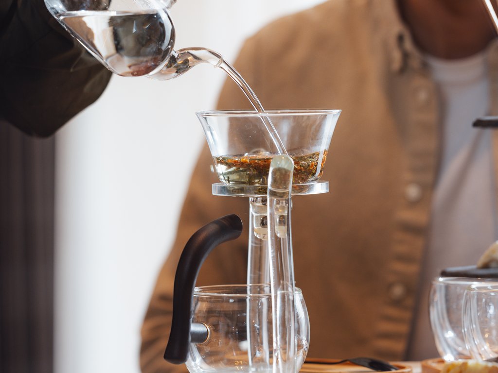 On the cycle track, from Moena to your romantic oasis Person pouring water from a teapot into a tea infuser on a table