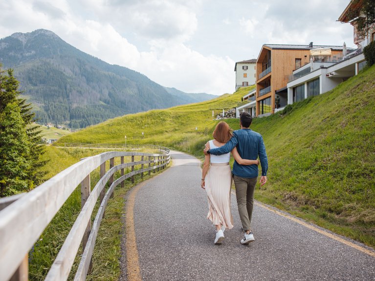 Hotel Latemar con vista sulle Dolomiti Coppia che cammina abbracciata su una strada di montagna panoramica