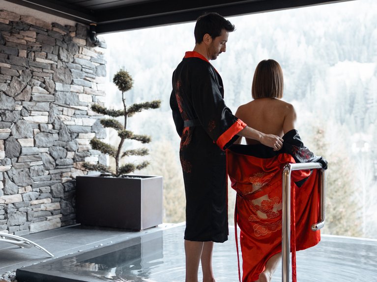 Hotel Latemar con vista sulle Dolomiti Coppia con kimono che entra in una piscina con vista sulle montagne