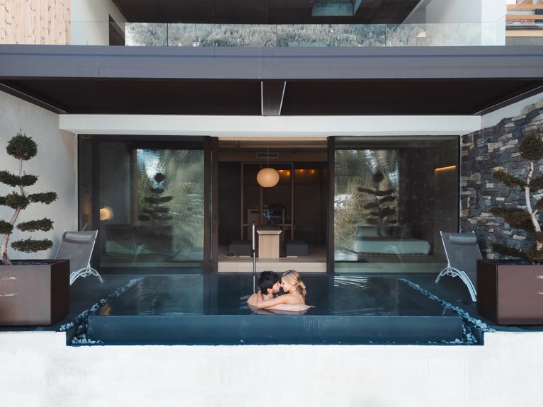Hotel Latemar con vista sulle Dolomiti Coppia che si abbraccia in una piscina privata moderna in un centro benessere