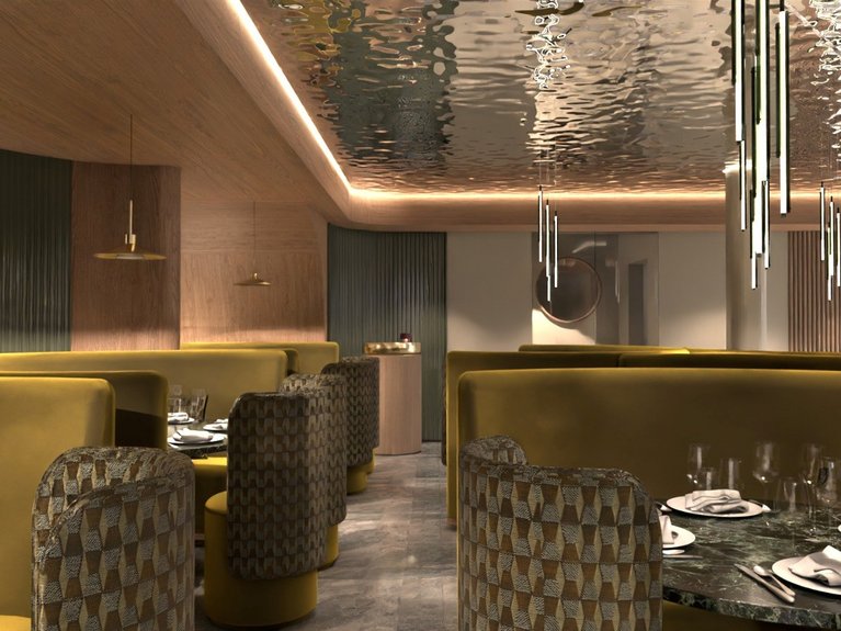 Hotel Latemar con vista sulle Dolomiti Interno di un ristorante elegante con sedute gialle e illuminazione moderna