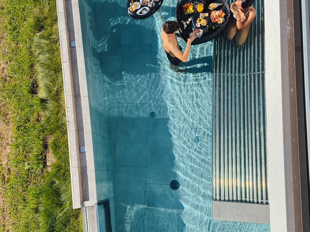 On the cycle track, from Moena to your romantic oasis People in pool with food on floating trays