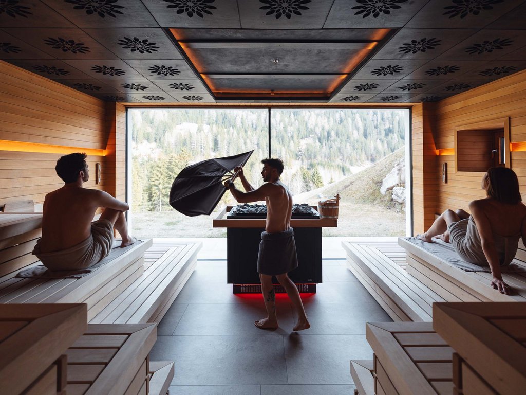 Hotel Latemar con vista sulle Dolomiti Interno di sauna moderna con tre persone avvolte in asciugamani
