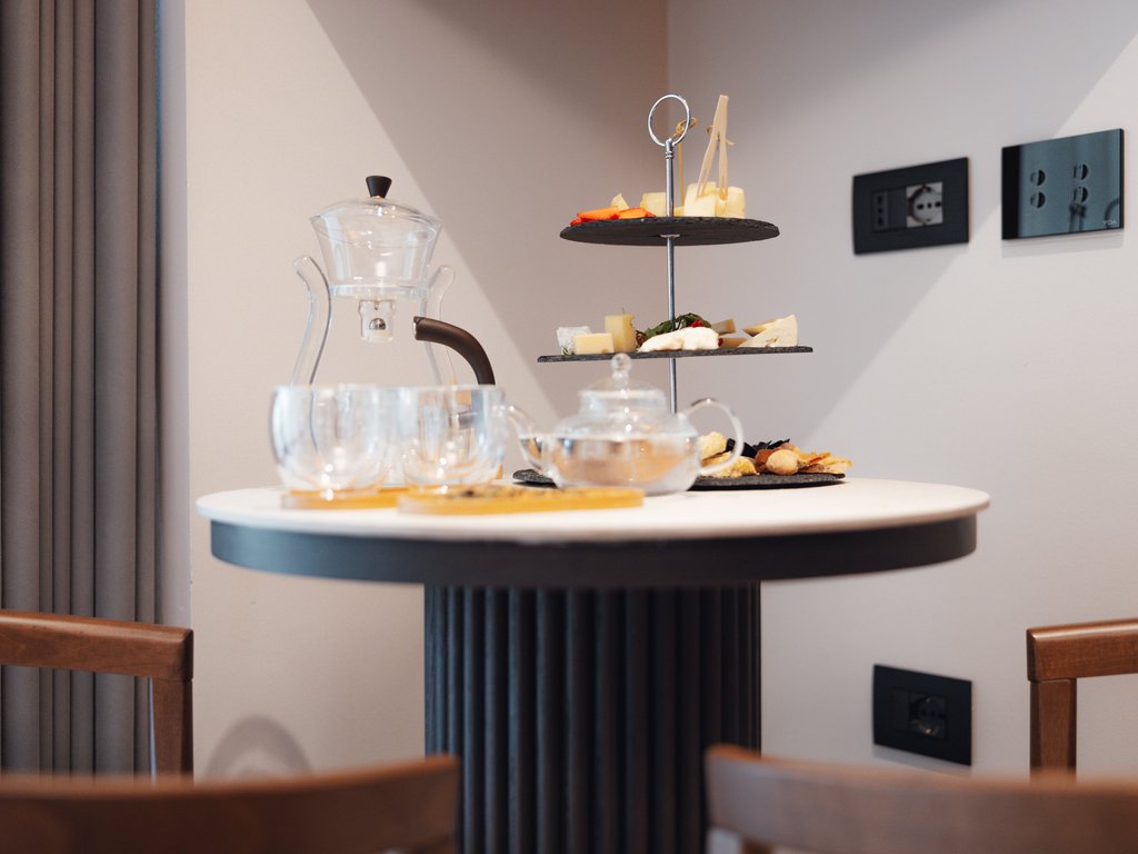 On the cycle track, from Moena to your romantic oasis Table with glass tea set and multi-tiered tray with snacks